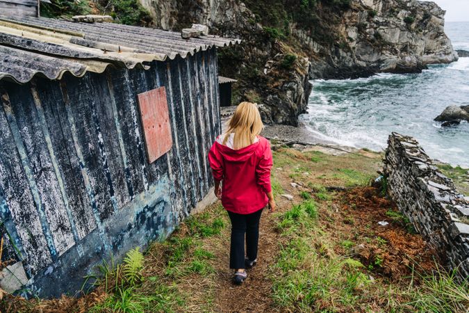 Woman walking down on stone steps leading down to foamy sea