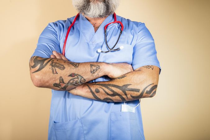 Cropped image of tattooed healthcare worker with stethoscope on neck