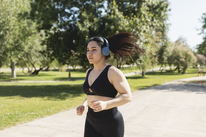 A young woman running and training concentrated, while listening to music with headphones, Zaragoza, Spain