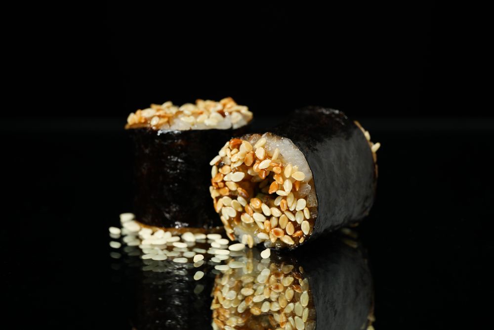 Delicious sushi rolls on dark mirror background. Japanese food