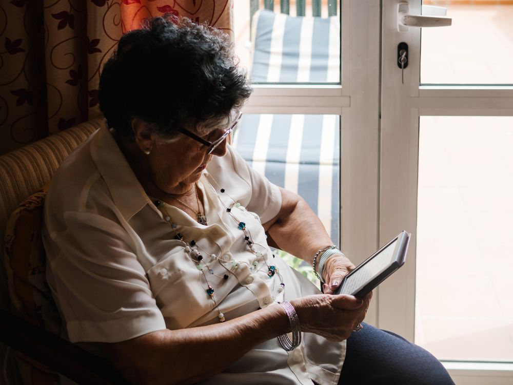 Older female reading e-book at home
