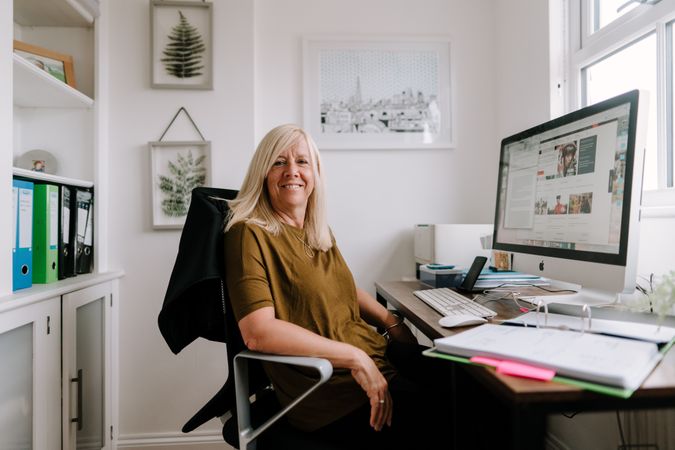 Woman with grey hair working from bright home office