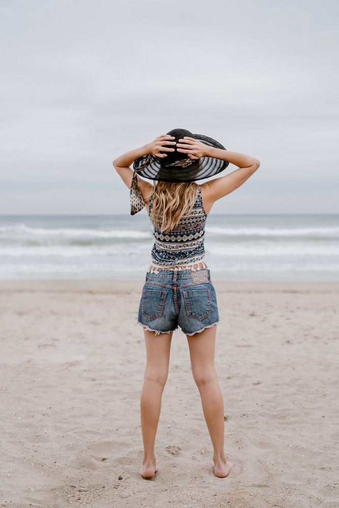 Young female relaxing on beach with hat