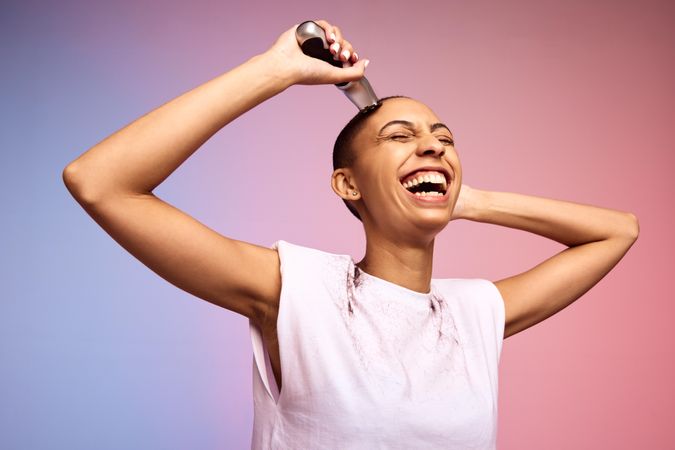 Smiling woman shaving her head
