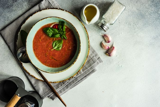 Top view of traditional gazpacho soup with olive oil, basil, garlic and pepper and copy space