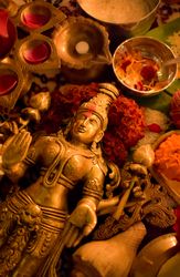 Top view of Buddha golden statue surrounded by diya and flowers