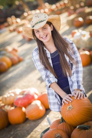 Preteen Girl Playing with a Wheelbarrow at the Pumpkin Patch.