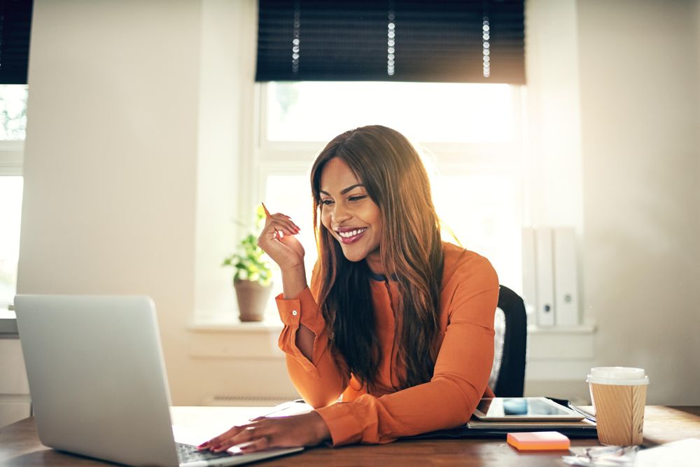 Businesswoman smiling in front of laptop in her office