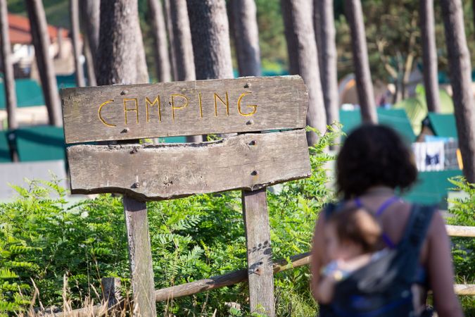 Female with baby looking at camping sign