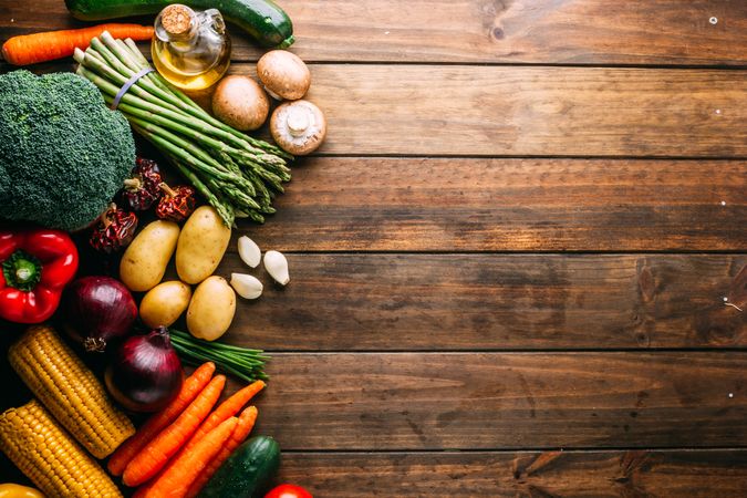 Various vegetables and oil on wooden tabletop