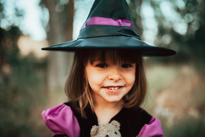 Portrait of smiling cute girl in witch costume