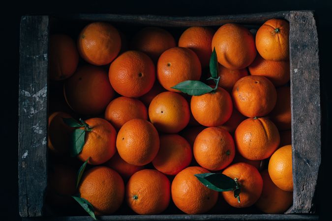 Fresh oranges in an old wooden box