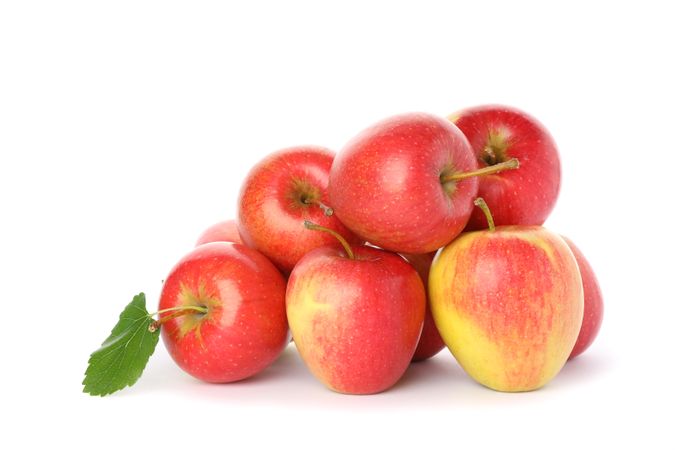 Pile of red apples isolated on light background