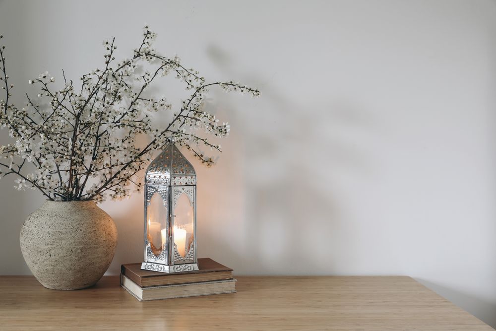 Glowing Moroccan lantern on books.