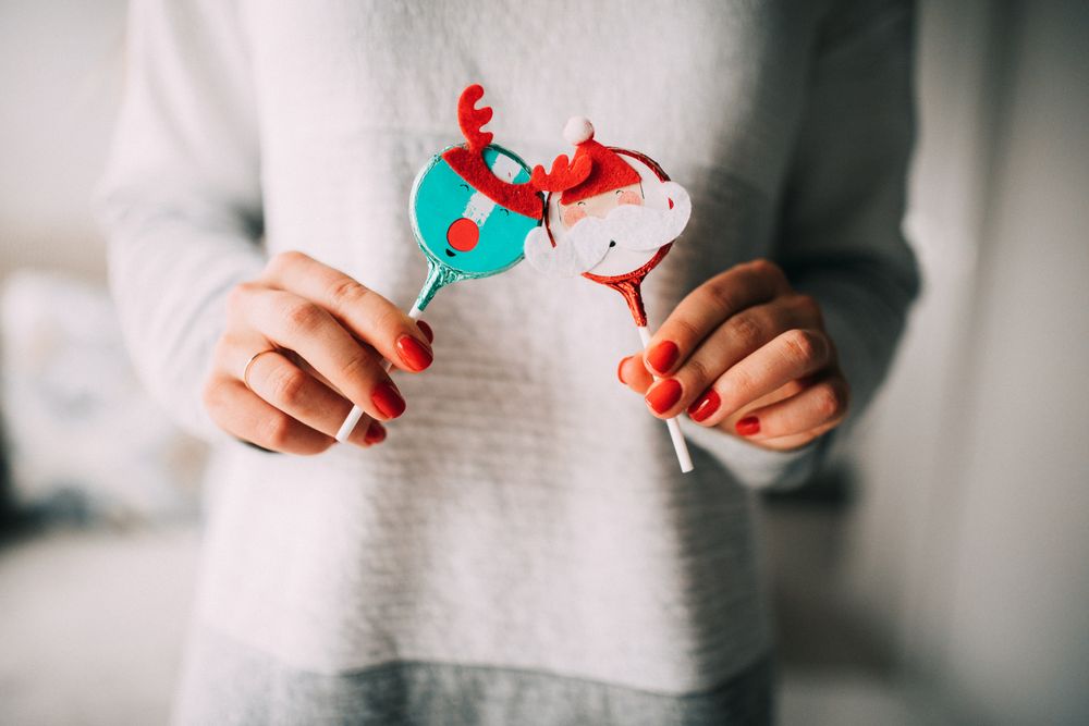 Woman holding festive reindeer and Santa edible ornaments