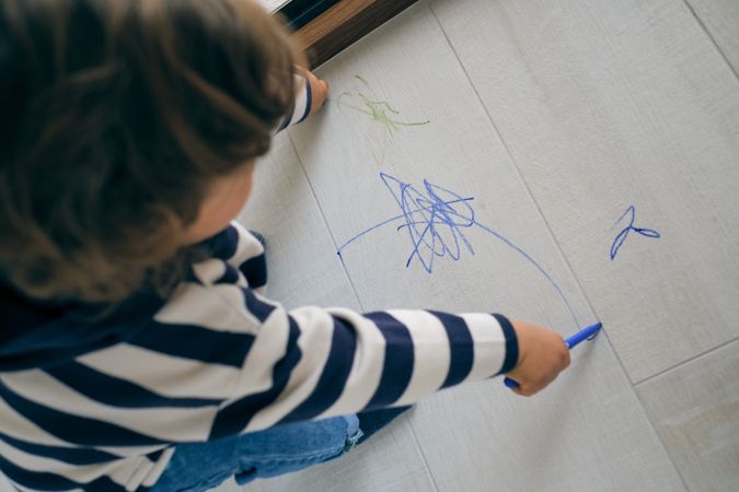Anonymous kid drawing on floor