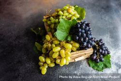 Box of fresh green & red grapes on dark grey kitchen counter 5aXWpo