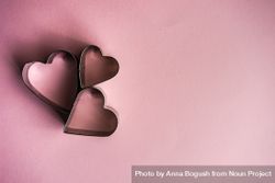Three heart shaped cookie cutters on pink background bGRRM2