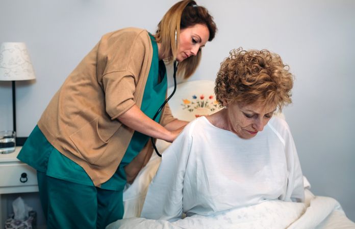 Caregiver auscultating woman