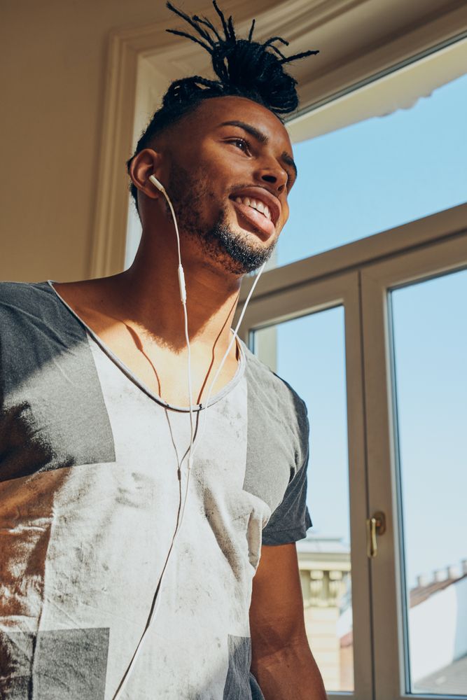 Cheerful Black male listening to music