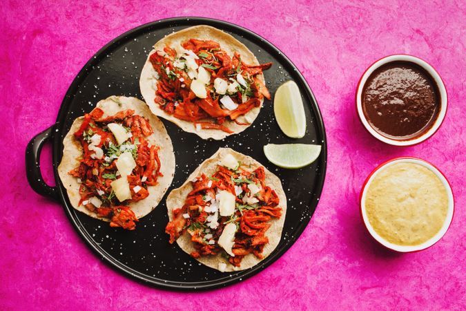 Pepper and lime near tacos al pastor and sauces