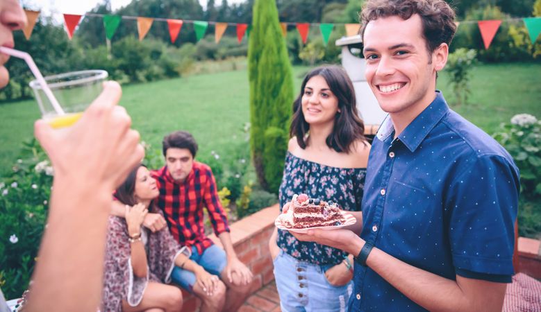 Man with piece of cake at a summer barbecue