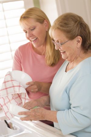 Older Adult Woman and Young Daughter Talking in Kitchen