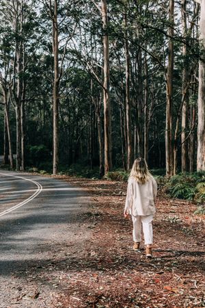 Back view of blonde woman walking in the woods