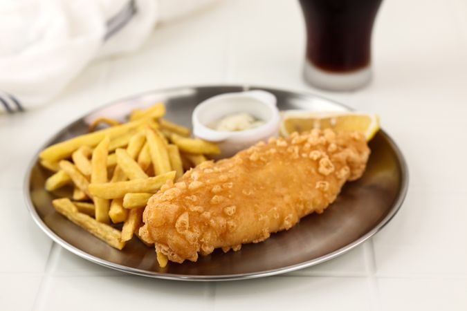 Fish and Chips is a Hot Dish of Fried Fish in Flour Batter on Metal Plate