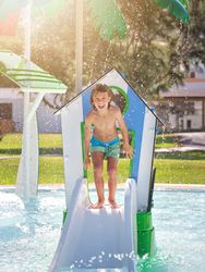 Young boy standing on deck of swimming pool