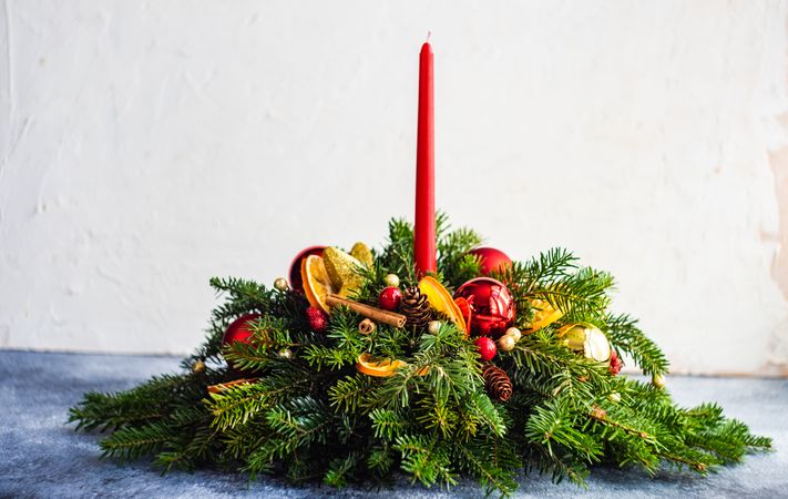 Center piece on holiday table with fir, baubles and candle