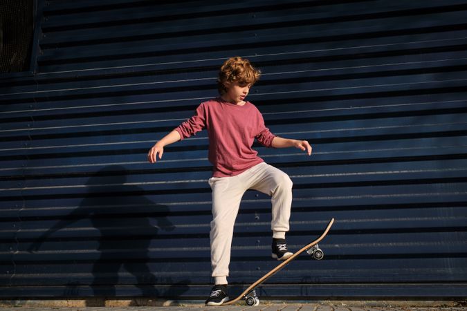 Boy doing stunt on skateboard on street
