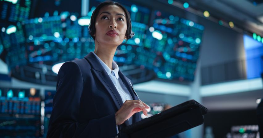 Portrait of a Young Stock Exchange Broker Using Tablet Computer, Researching Real-Time Stocks Data, Analyzing Commodities and Exchange Market Charts.