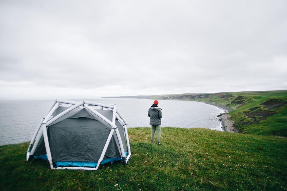 Back of man standing next to tent