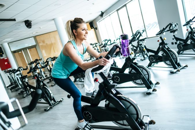 Woman with towel and water on exercise machine