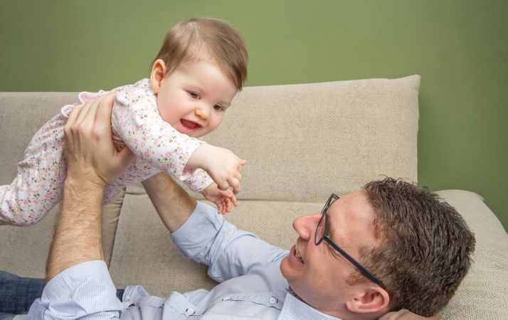 Father lifting cute baby above his chest