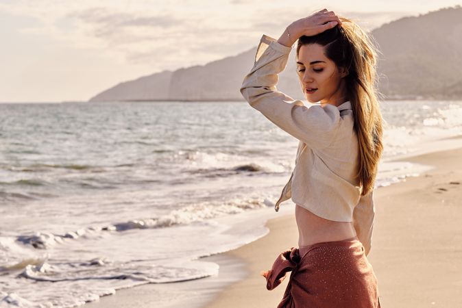 A fashion model at the beach before sunset
