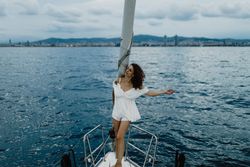 Barefoot bride resting on yacht bow