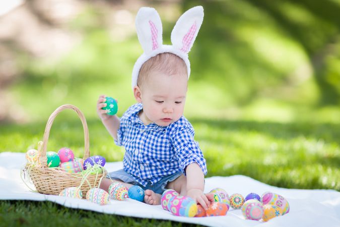 Biracial Baby Boy In Rabbit Ears Playing with Easter Eggs