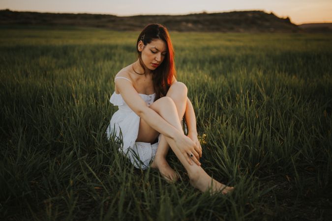Barefoot woman with flowers in meadow