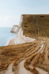 Limestone cliffs with withered grass by water