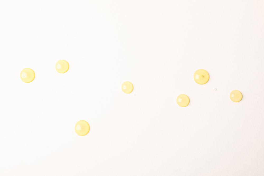 Honey drops on plain background, space for text