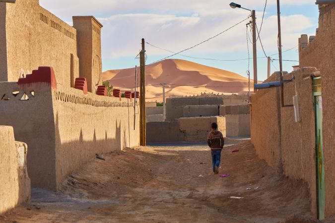 Person between ancient buildings on street