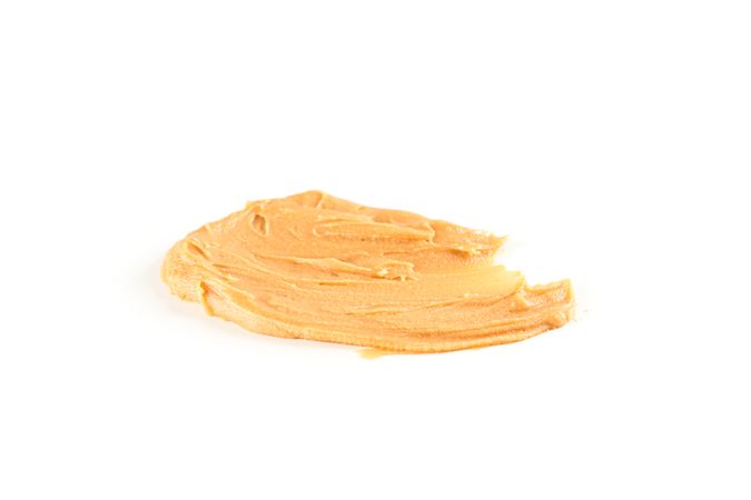 Creamy peanut butter isolated on bright background. A traditional product of American cuisine