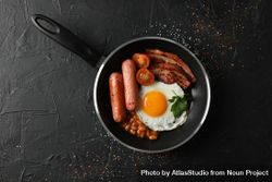 Top view of breakfast in pan with eggs, tomatoes, sausage and bacon 49LwQ5