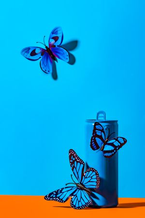 Plastic butterflies on metal blue can
