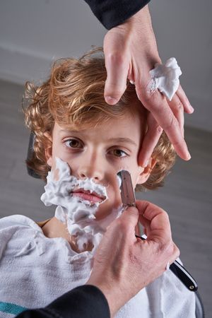 Boy shaving in a barbershop