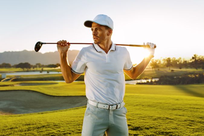 Male golfer with golf club at course