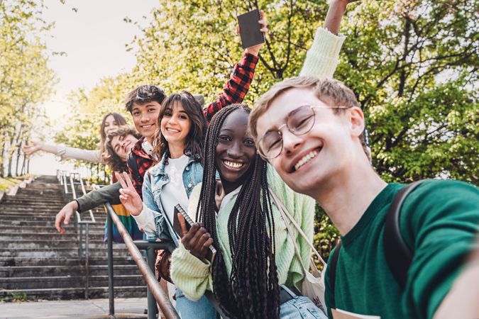 Students taking selfie on stairs outside on campus