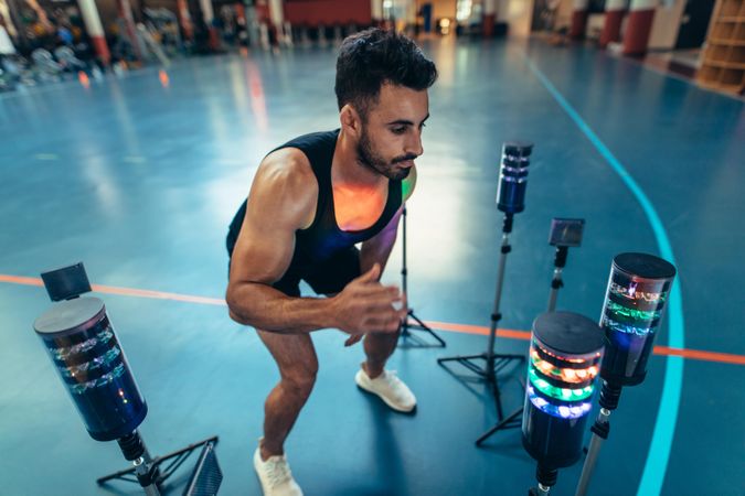 Man exercising with lights around to improve reaction time at gym